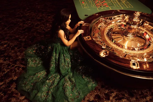 A glamorous woman holding casino chips in a neon-lit environment, representing the premium online casino atmosphere of HOKI678.